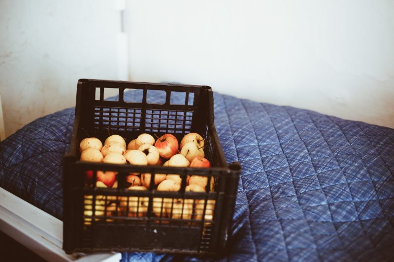 Kiste mit Äpfel auf einem Bett